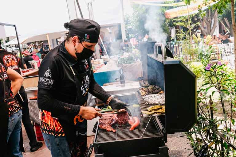 ortes de carne asándose al carbón en una parrilla durante un evento gastronómico tradicional en el estado de Guanajuato.